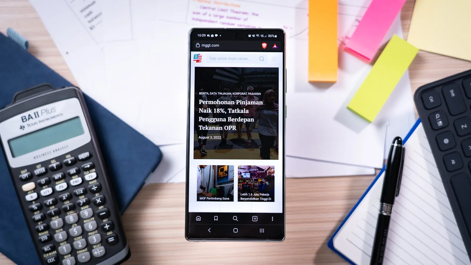 Rekenmachine, smartphone en aantekeningen op een bureau